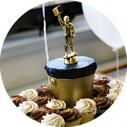 A miniature paperboy towers over cupcakes for the guests.